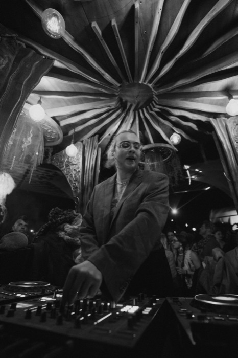DJ set beneath the sunburst timber roof, black and white