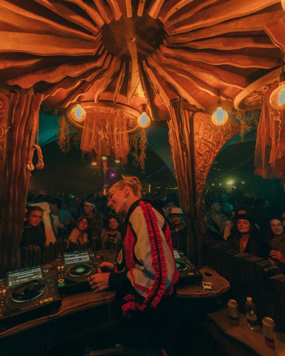 DJ set beneath the sunburst timber roof at dusk