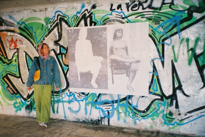 Standing beside the frame by frame animation piece pasted on a graffitied wall